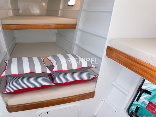 La cabine à trois couchettes. Au total le catamaran dispose de deux cabines doubles, d'une cabine triple et de deux salles de bain. La cabine et les sanitaires du skipper sont à part.