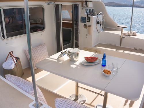 Dans les îles grecques où la douceur du climat invite à être dehors, le salon extérieur du catamaran Punch offre une espace convivial pour les repas et les moments de détente.